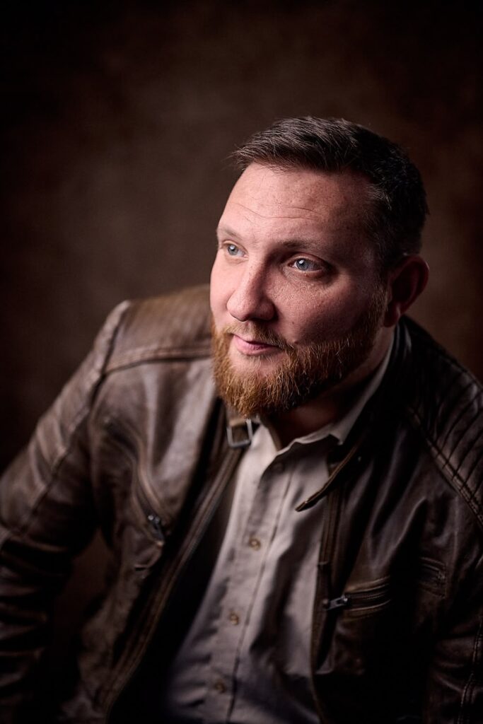 Portrait of man in grey shirt with brown leather jacket
